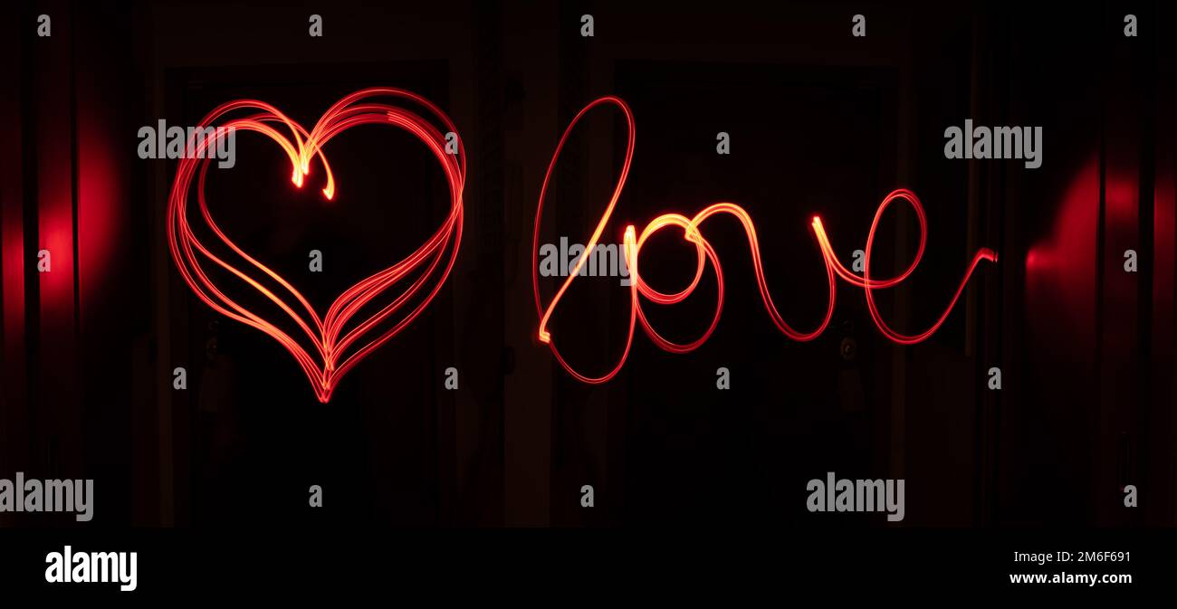 Red light track writing love and drawing a heart. Stock Photo