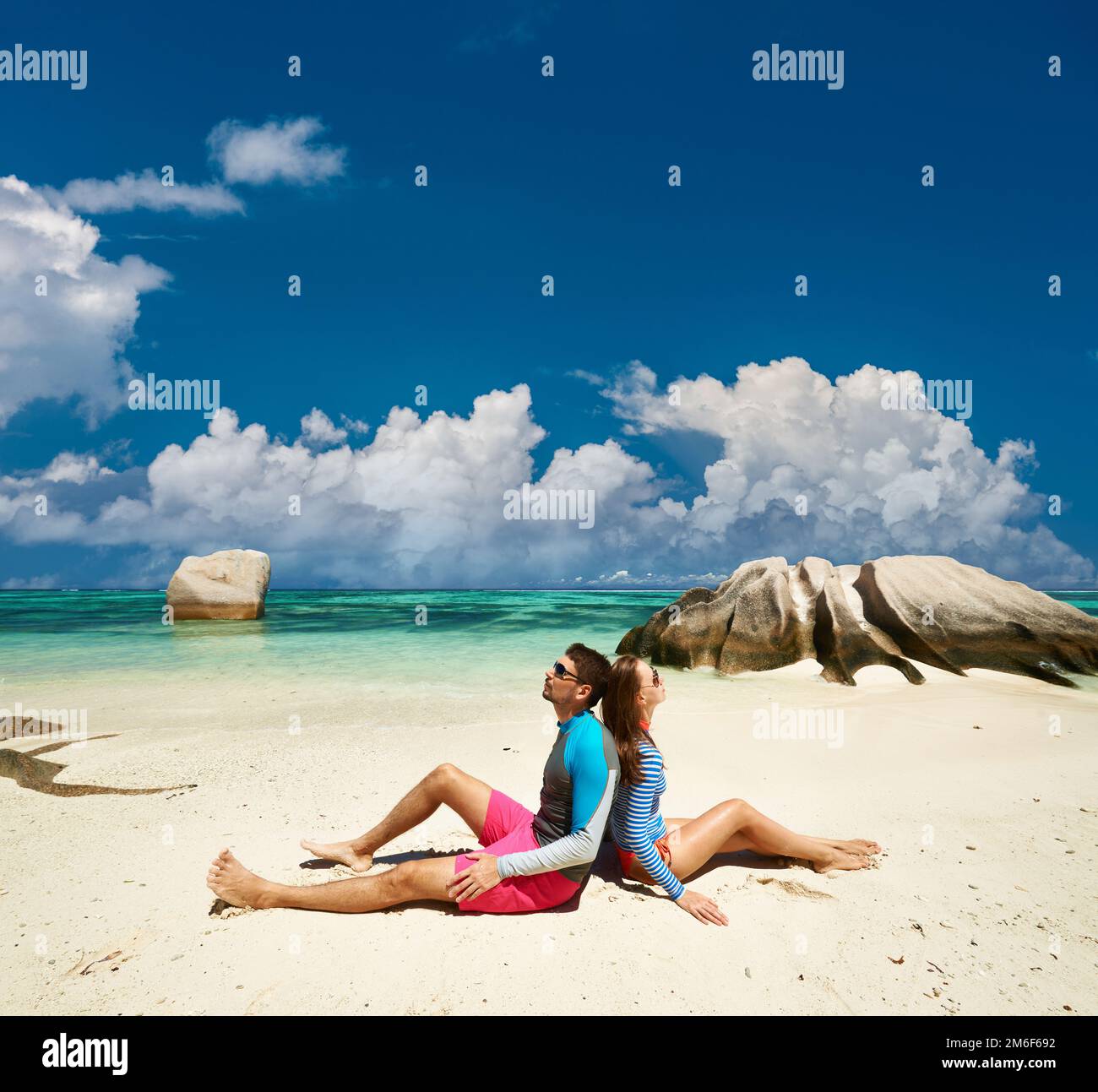 Couple at tropical beach wearing rash guard Stock Photo Alamy