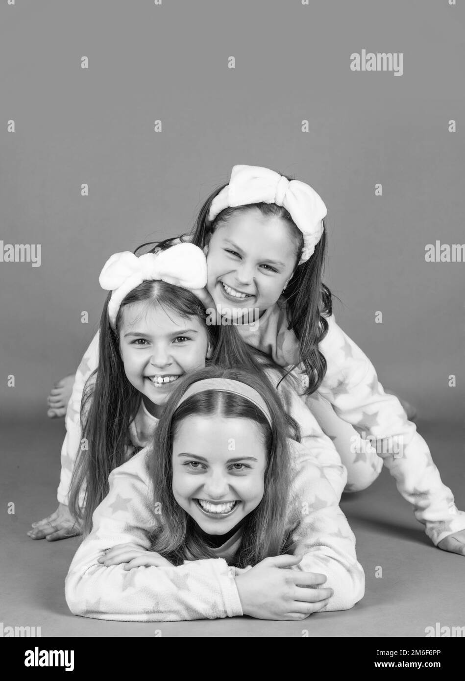 Pajama party is a real laugh. Happy sisters laughing lying close on each other. Laugh and be happy Stock Photo