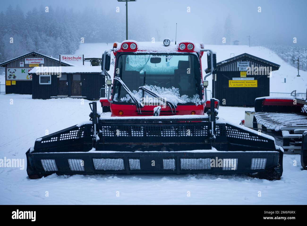 Frontal view of a snowcat in front of a ski slope Stock Photo
