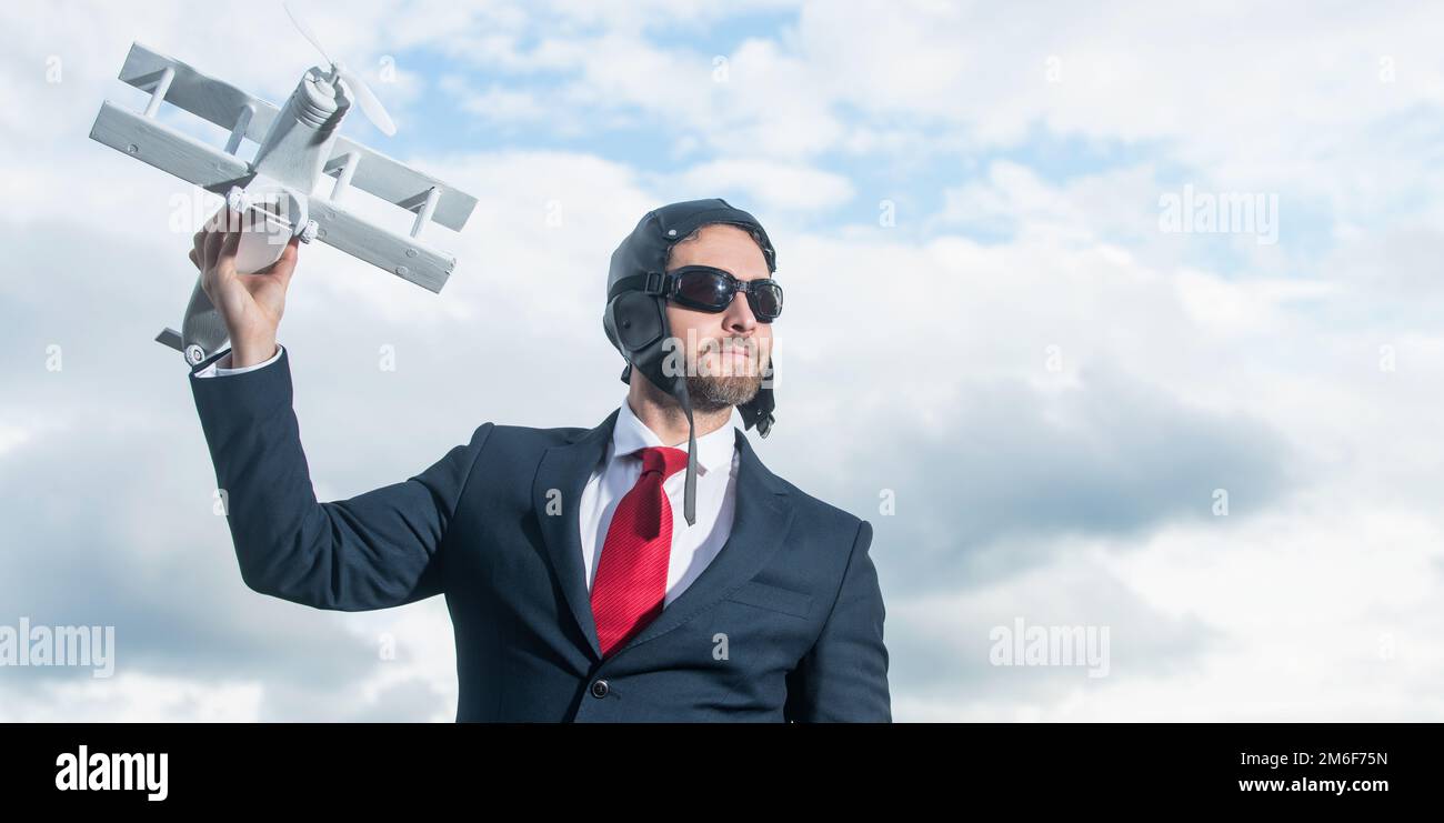 dreaming businessman in suit and pilot hat launch plane toy Stock Photo