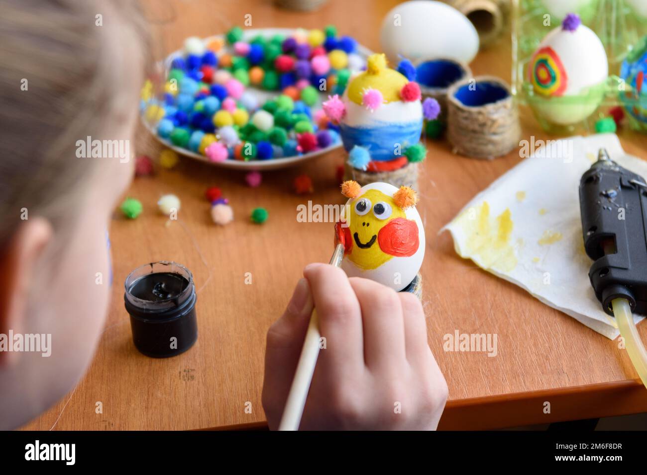 Girl beautifully paints Easter eggs Stock Photo