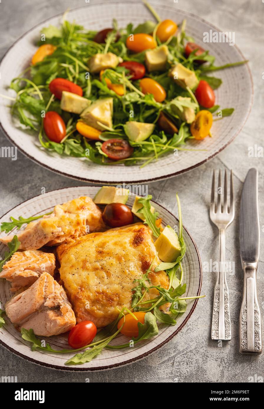 Salmon baked with cheese, served with vegetables. Stock Photo