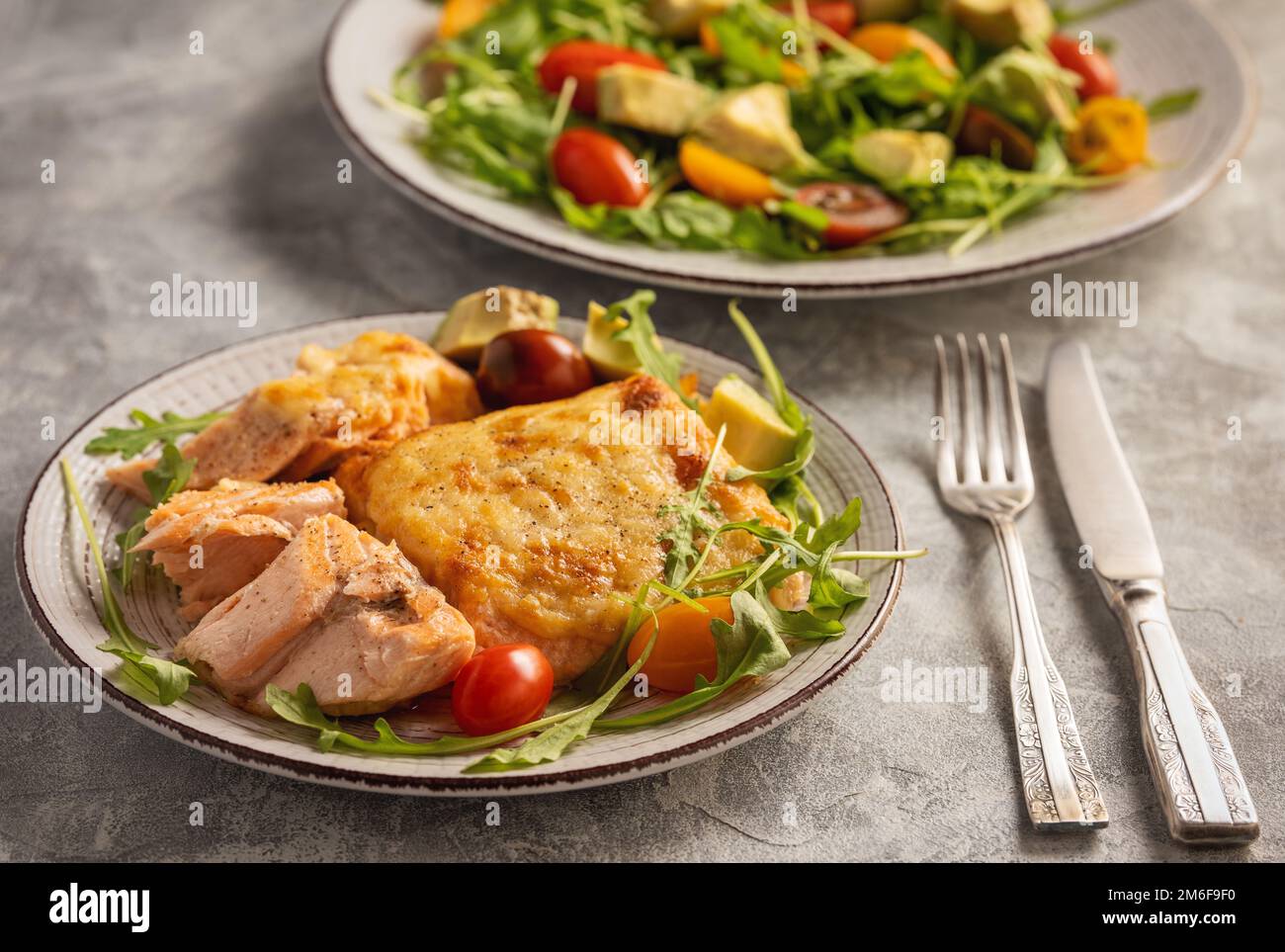 Salmon baked with cheese, served with vegetables. Stock Photo
