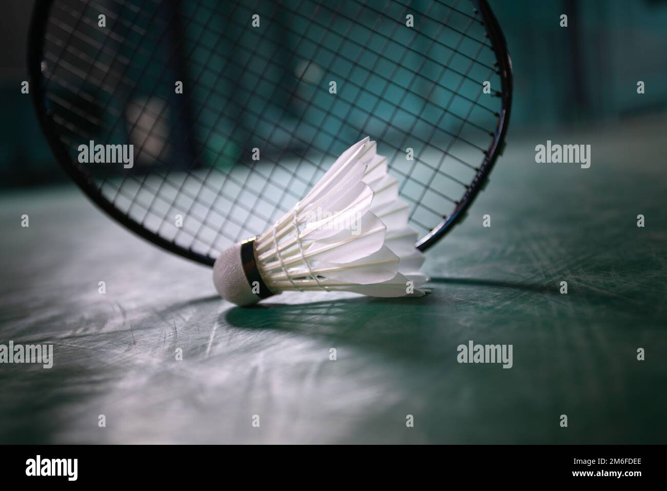 badminton ball or shuttle cock with badminton racquet in court