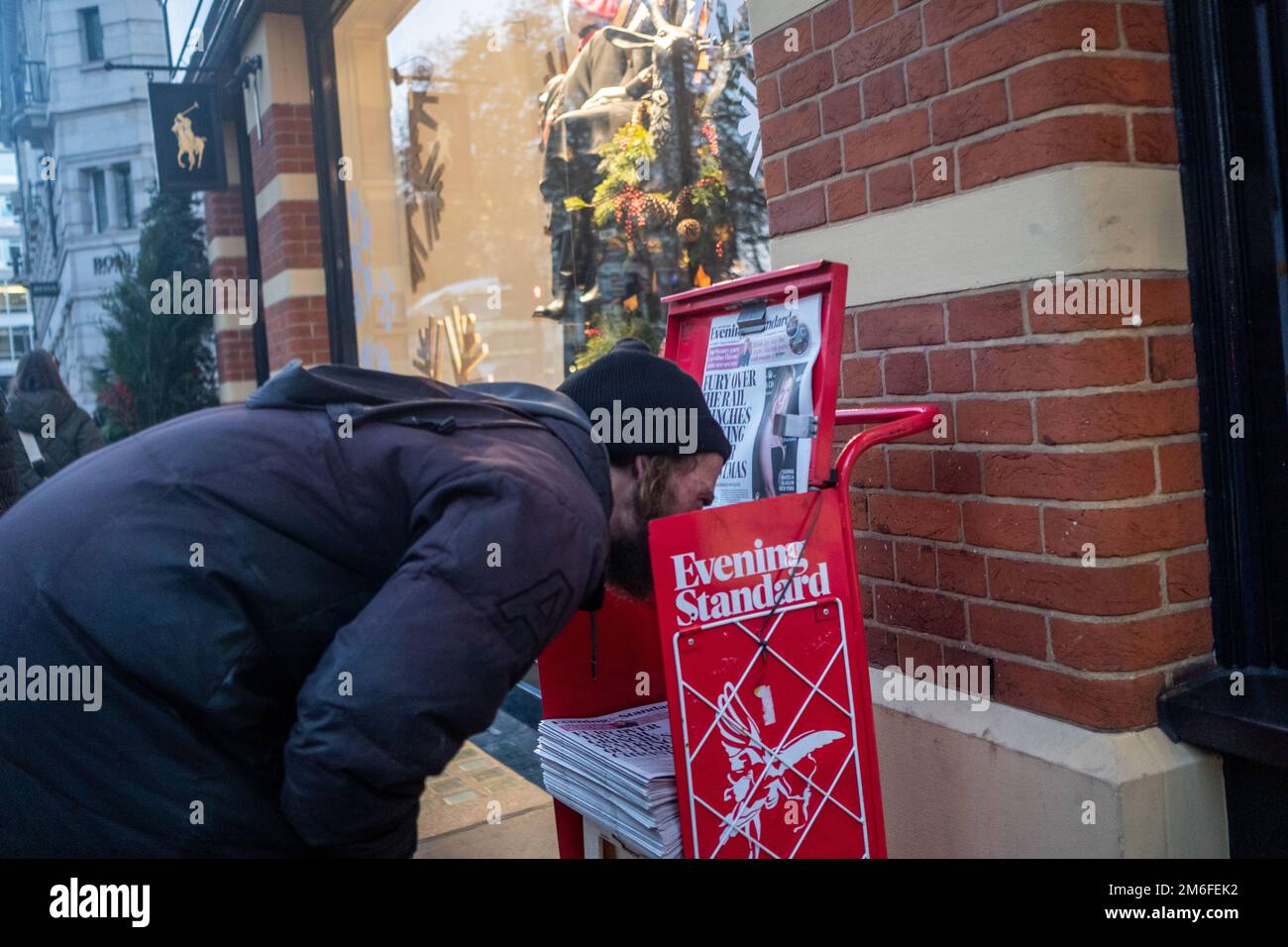 London- December 2022: A man taking a very close look at the news Stock Photo
