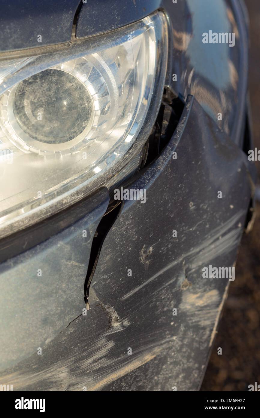 Closeup of side part of auto wheel and fender with cracks, dents and  scratches after road accident, broken vehicle with destroyed auto body.  Outdoor shot. Stock Photo