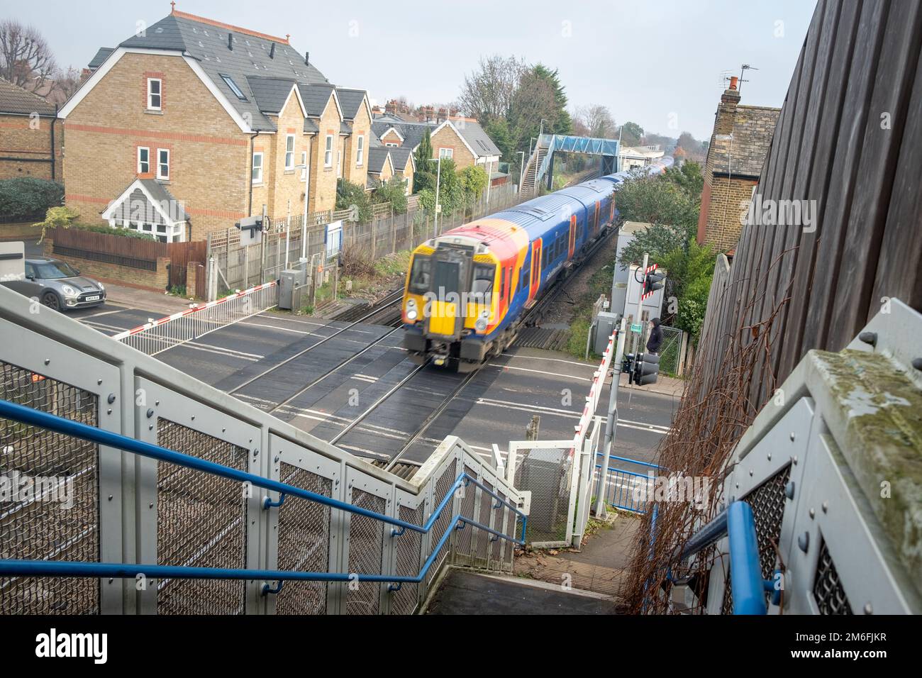 London- December 2022: South Western Railway train passing over a level crossing in Richmond area of south west London Stock Photo