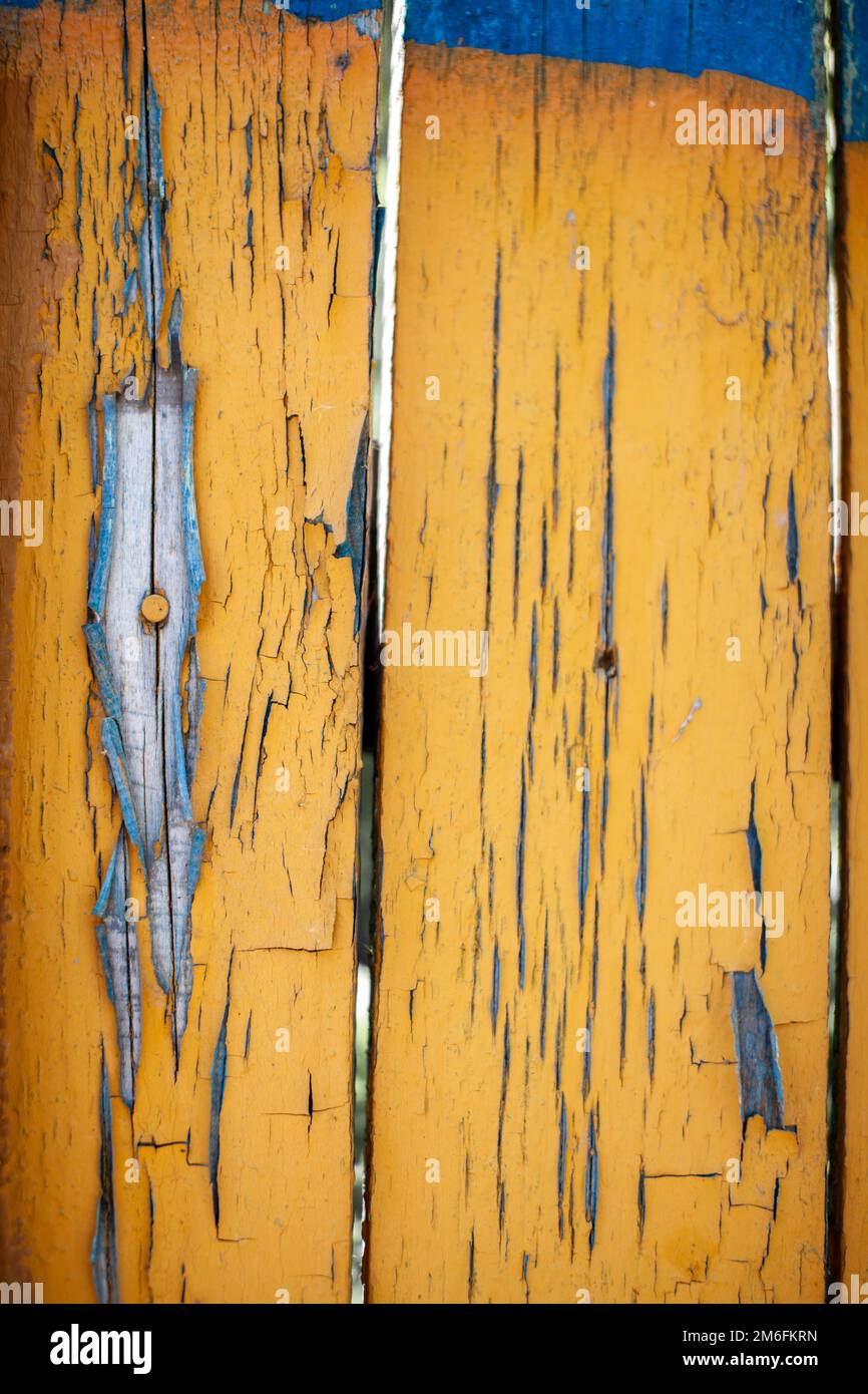 Wood texture with yellow flaked paint. Peeling paint on weathered wood Stock Photo