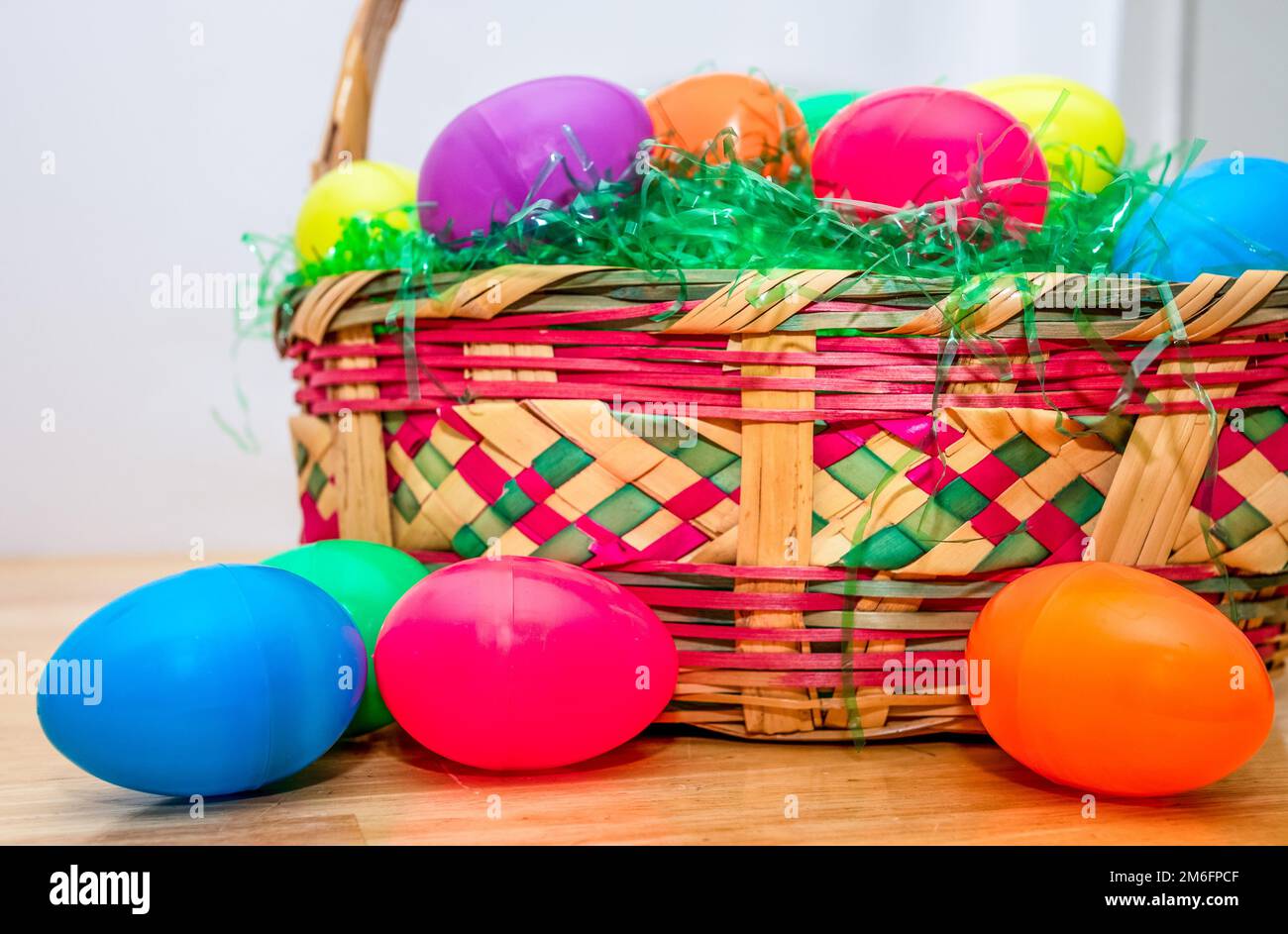 Wicker Easter basket with vintage colorful plastic Easter eggs. Stock Photo