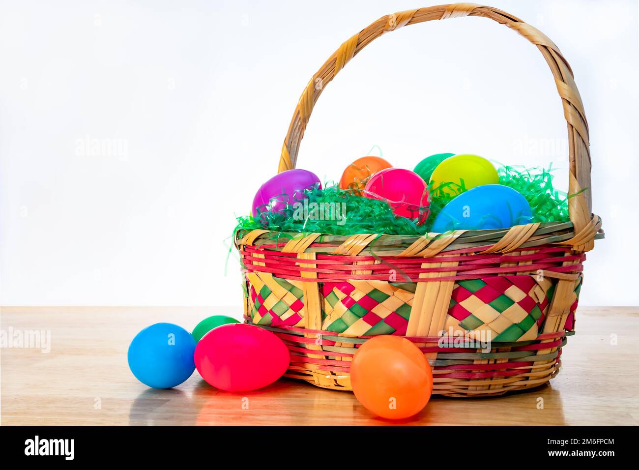 Wicker Easter basket with vintage colorful plastic Easter eggs. Stock Photo