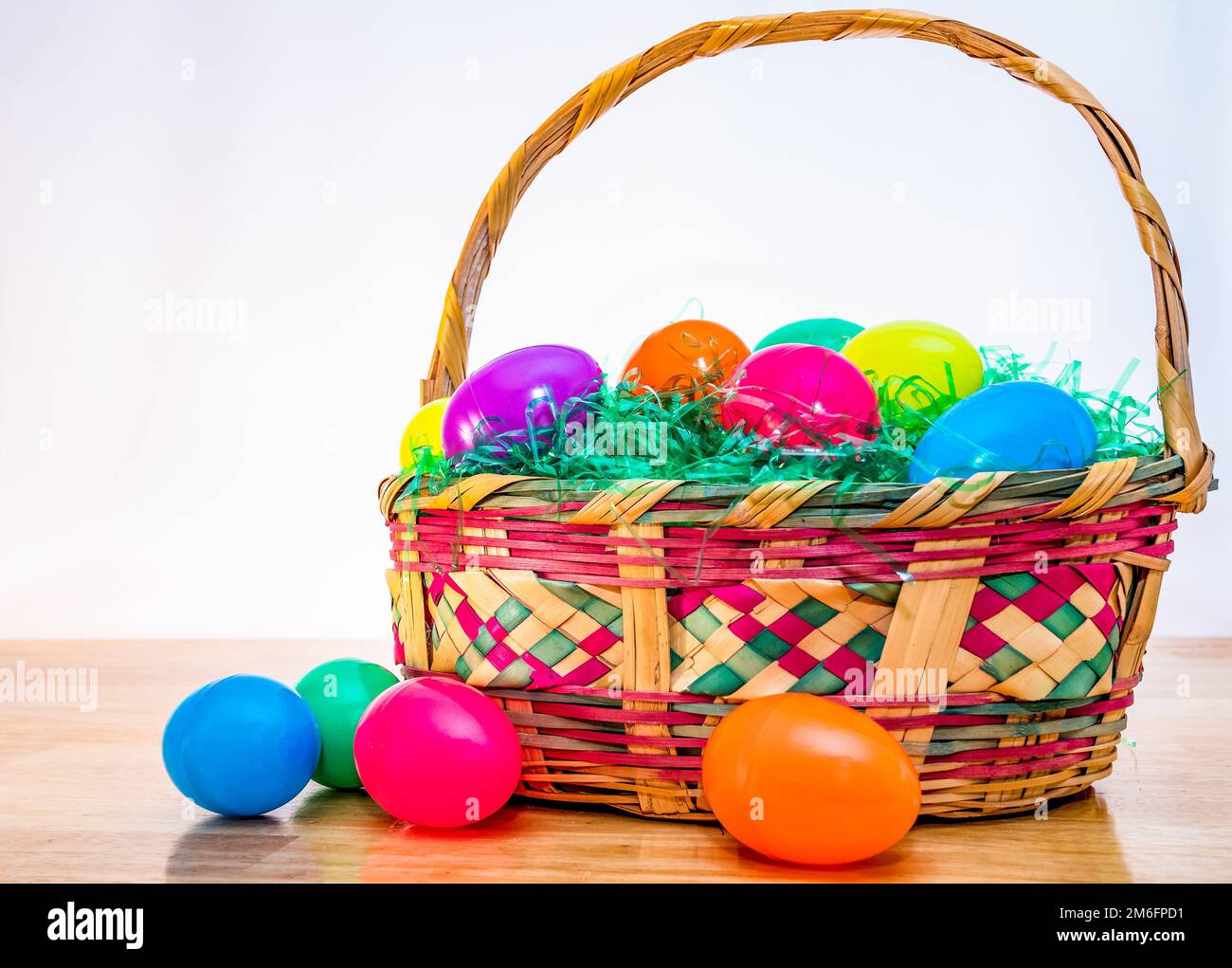 Woven Easter basket with vintage colorful plastic Easter eggs. Stock Photo