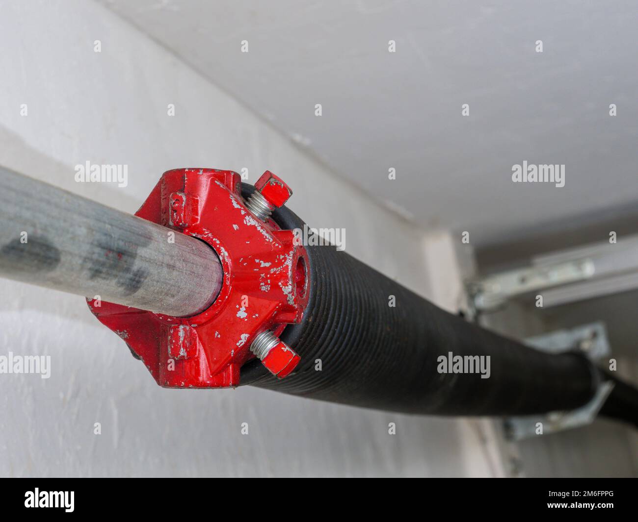 Electric garage door opener coiled tension spring. Stock Photo