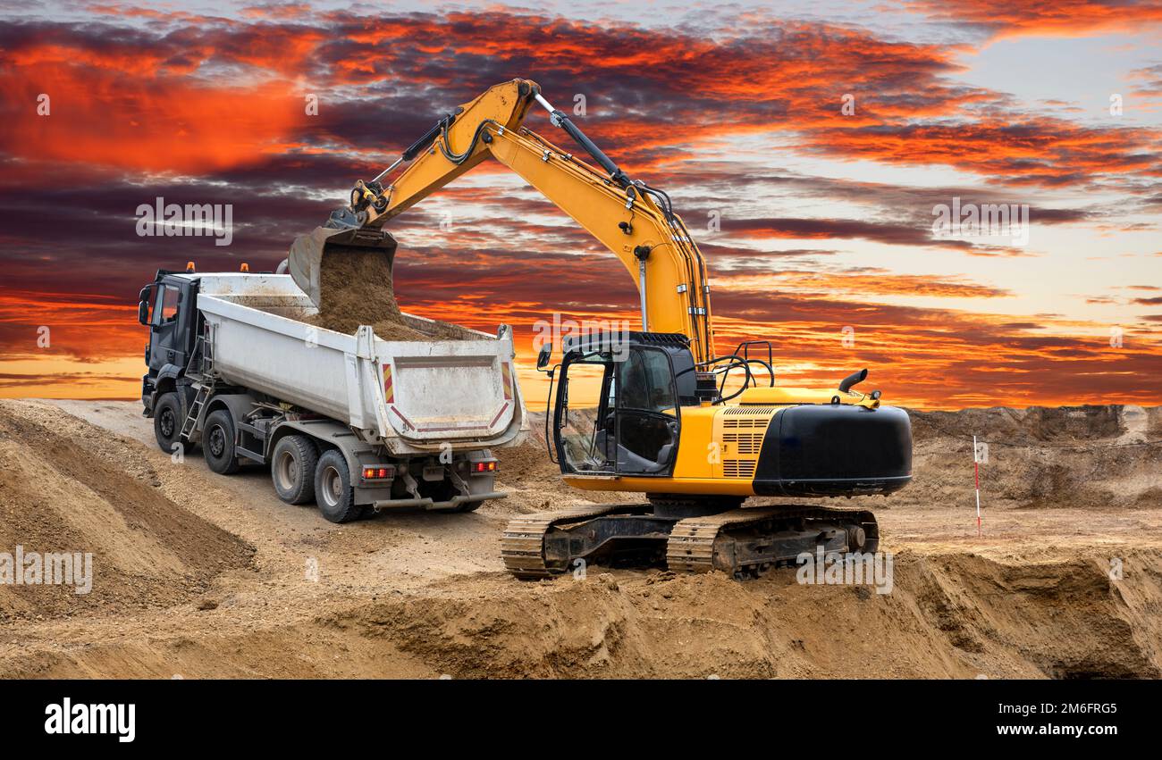 Excavator working on construction site with dramatic clouds Stock Photo ...