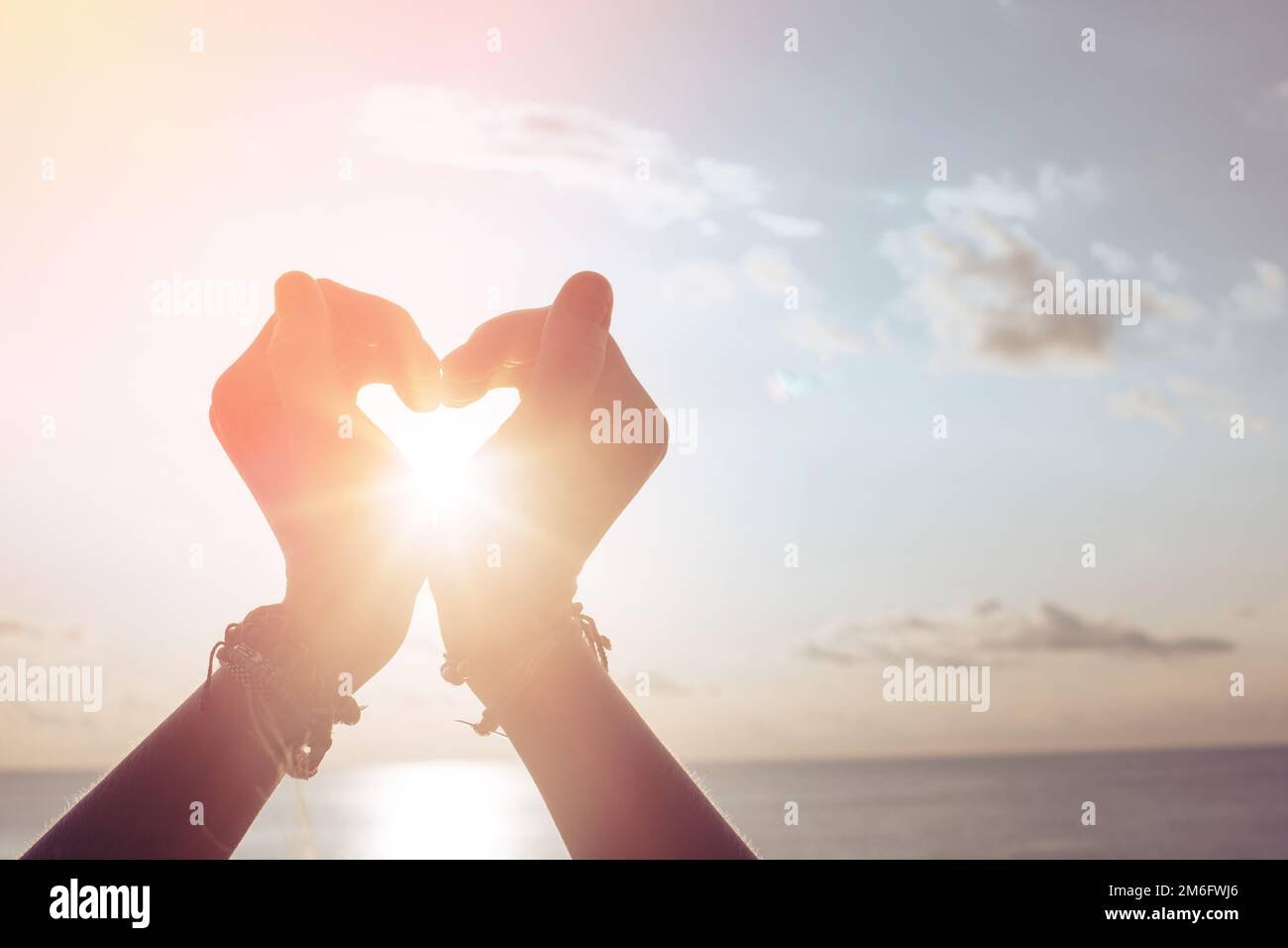 Woman holds hands up to sky in the shape of a heart Stock Photo - Alamy