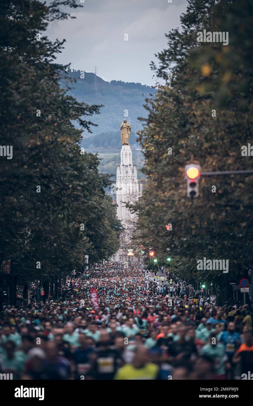 Many runners in the Bilbao Night Marathon, running in the streets of ...