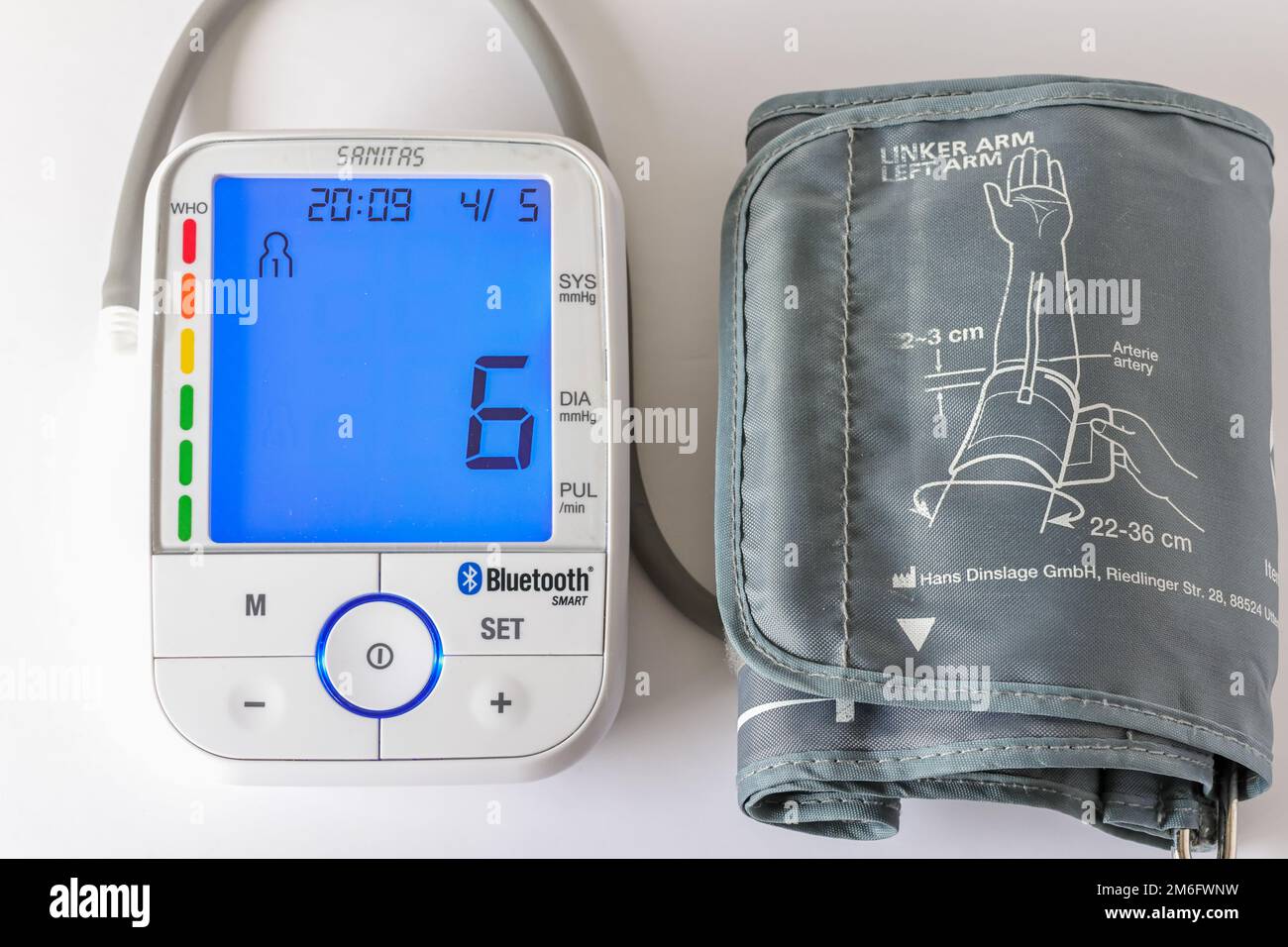 A Sanitas brand digital arm blood pressure monitor and blood pressure pills  on a white surface Stock Photo - Alamy