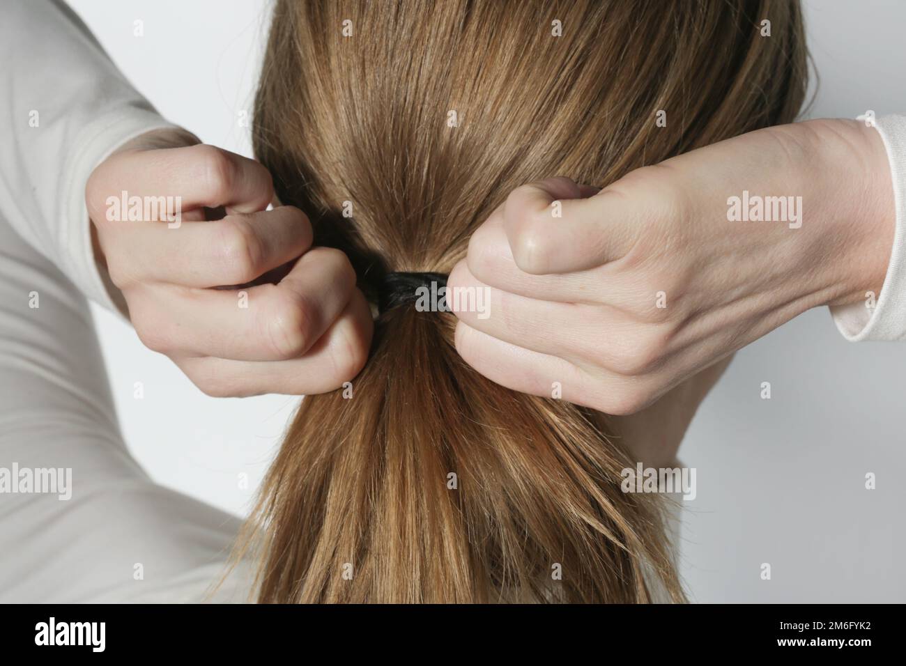 Serie of photos of making a low ponytail with basic elastic hair band