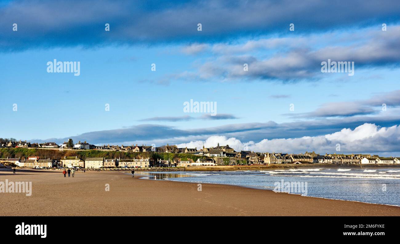 Lossiemouth East Beach Moray coast Scotland walkers and houses seen from the beach in winter Stock Photo