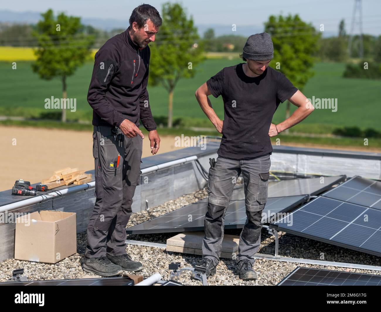 Male team engineers installing stand-alone solar photovoltaic panel ...