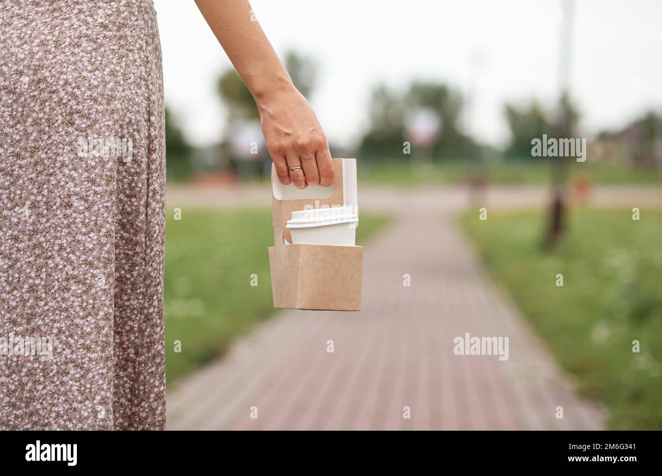 White paper cup with coffee in woman hand. Time for drink coffee Stock Photo