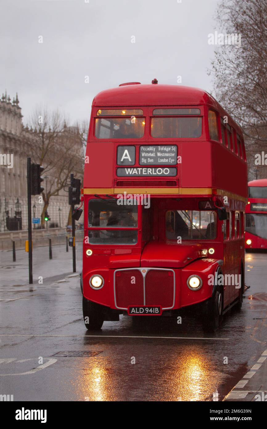Classic red London double-decker bus with destination Waterloo sign. Reflections fom headlights in wet street. Stock Photo