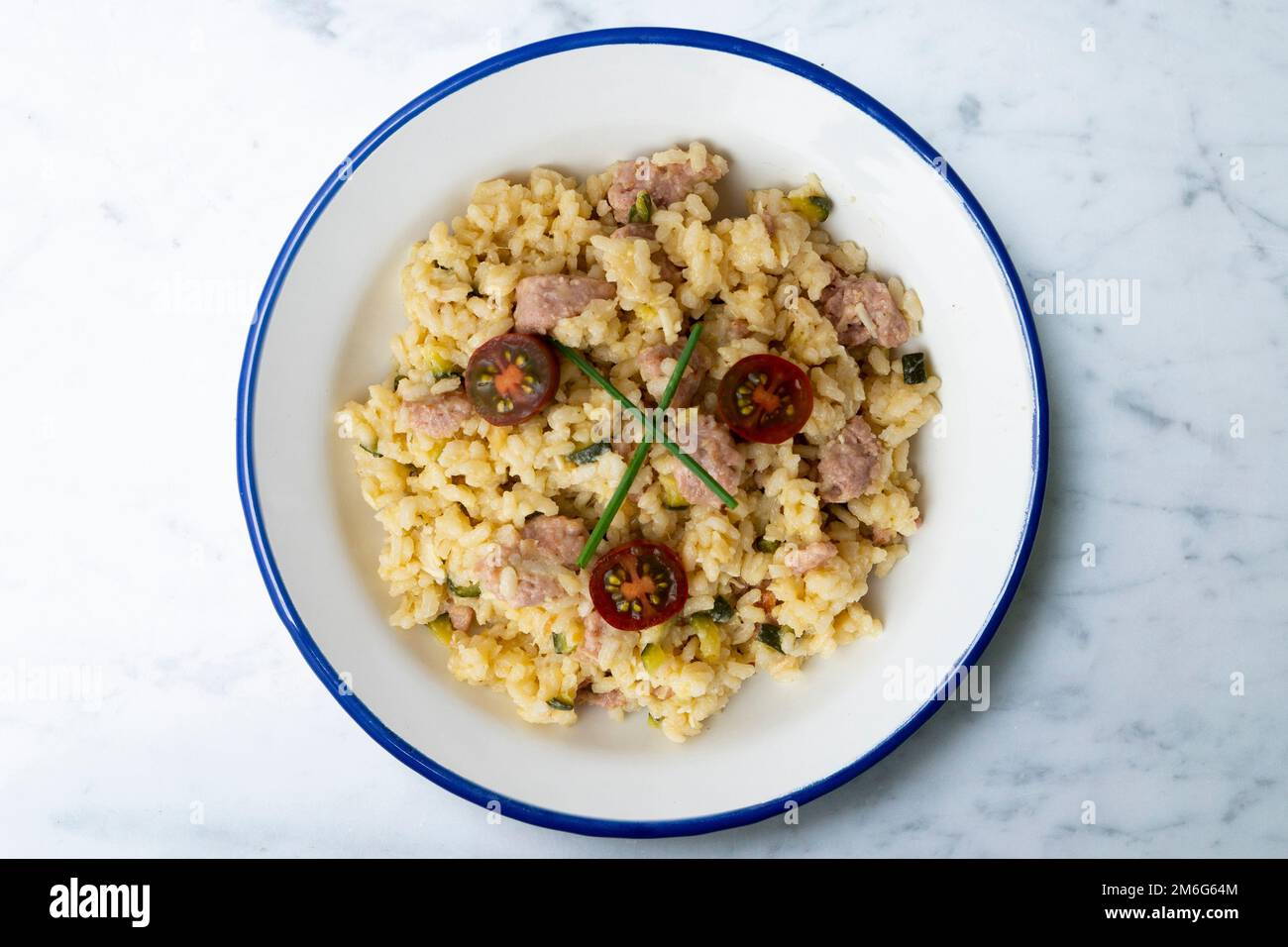 Risotto with pork sausage and cherry tomatoes. Risotto is a northern