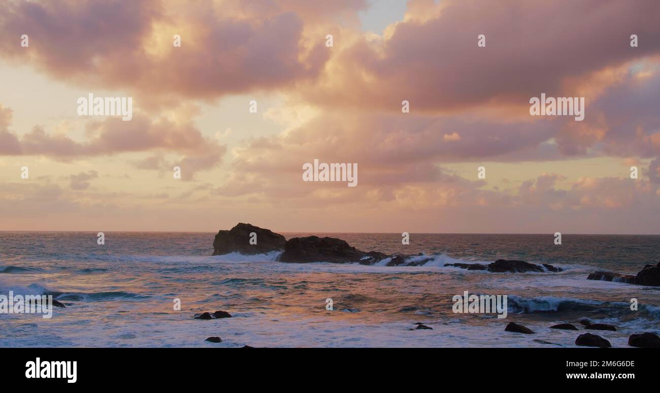 Ocean waves crashing on volcanic rocky shore. Sunset seascape at ...