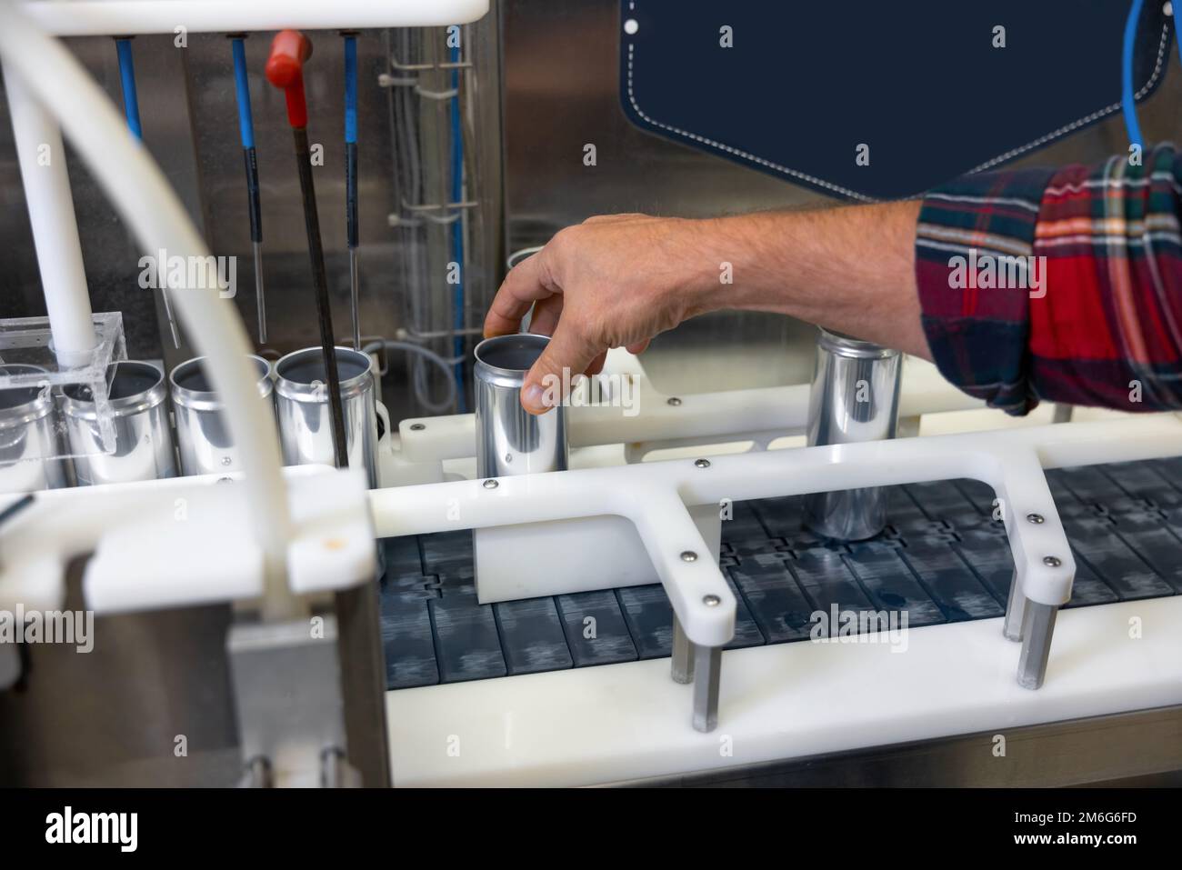 Skilled production worker using modern beer canning equipment Stock Photo