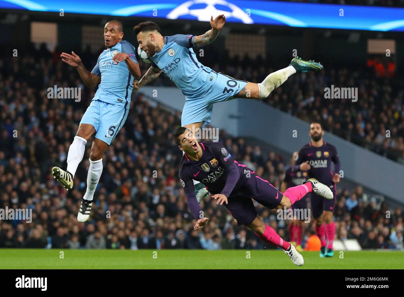 Luis Suarez of Barcelona goes to ground as Fernando (right) and Nicolas Otamendi (right) of Manchester City battle for the ball - Manchester City v Barcelona, UEFA Champions League, Etihad Stadium, Manchester - 1st November 2016. Stock Photo