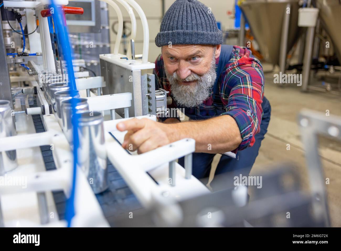 Concentrated factory operative monitoring the beverage canning process ...