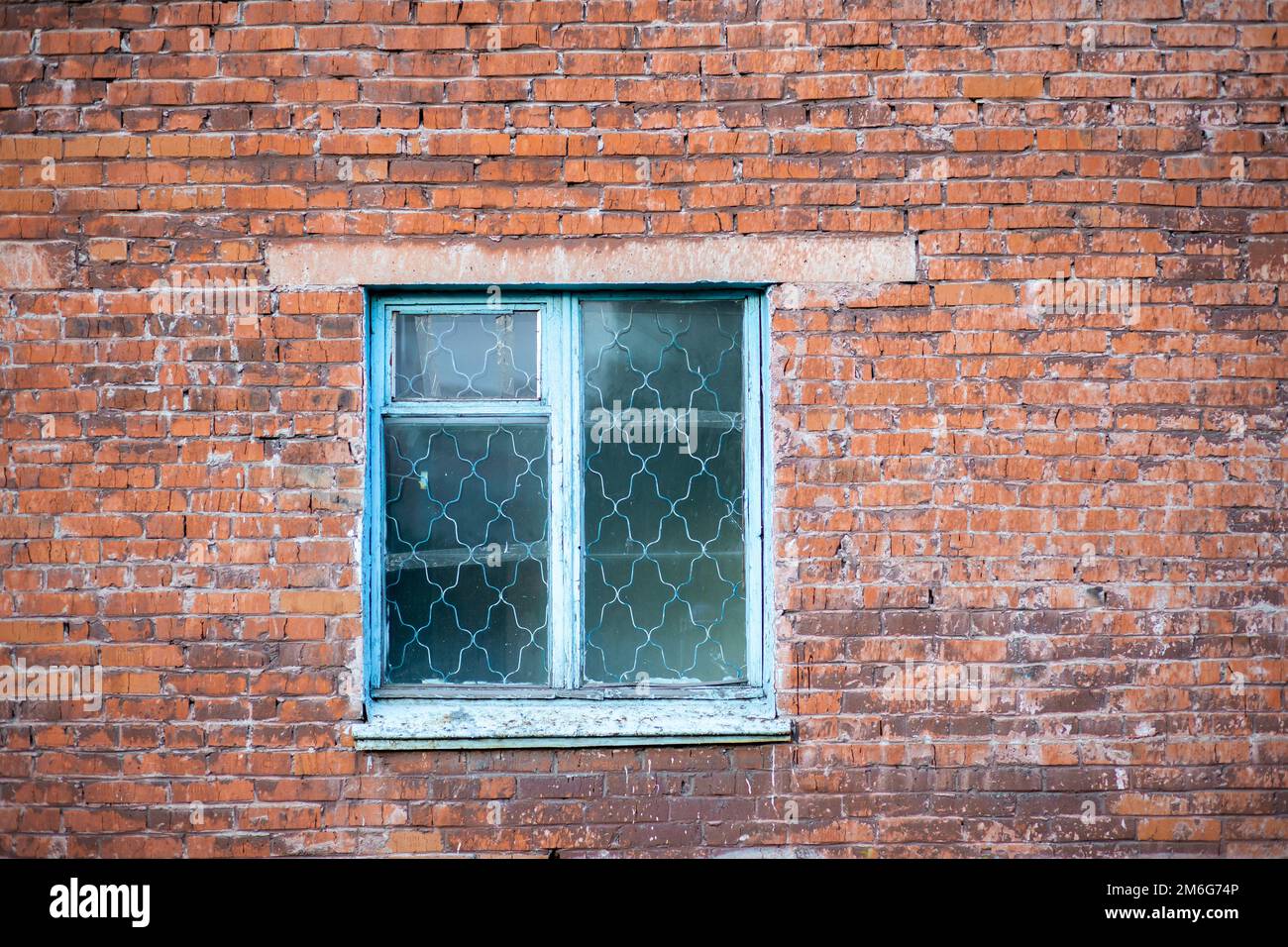 Old shabby wall facade of a brick building with wooden glass windows ...