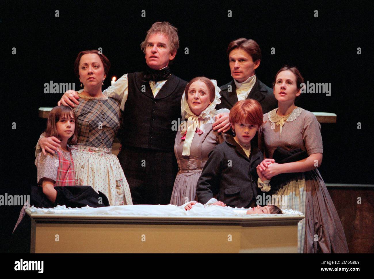 mourning Tiny Tim - rear, l-r: Sara Weymouth (Martha), Polly James (Mrs Cratchit), Paul Greenwood (Bob Cratchit), Roger Moss (Peter), Vicky Blake (Belinda) in A CHRISTMAS CAROL by Charles Dickens at the Royal Shakespeare Company (RSC), Barbican Theatre, Barbican Centre, London EC2  07/12/1995   adapted by John Mortimer  music: Nigel Hess  set design: John Gunter  costumes: Deirdre Clancy  lighting: Nigel Levings  choreography: Lindsay Dolan  director: Ian Judge Stock Photo