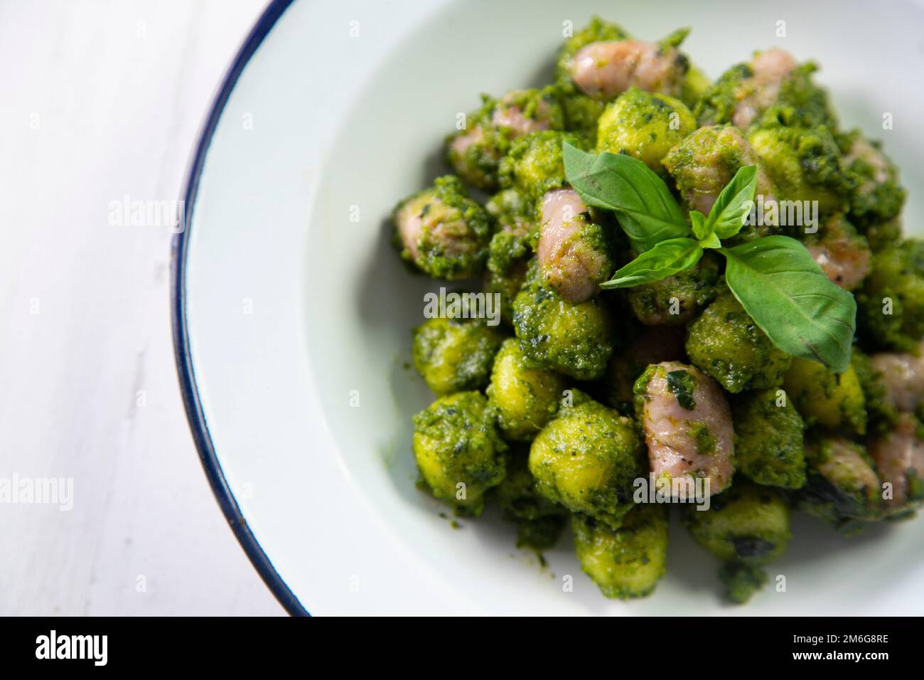 Gnocchi with pesto sauce and grilled pork sausages Stock Photo Alamy