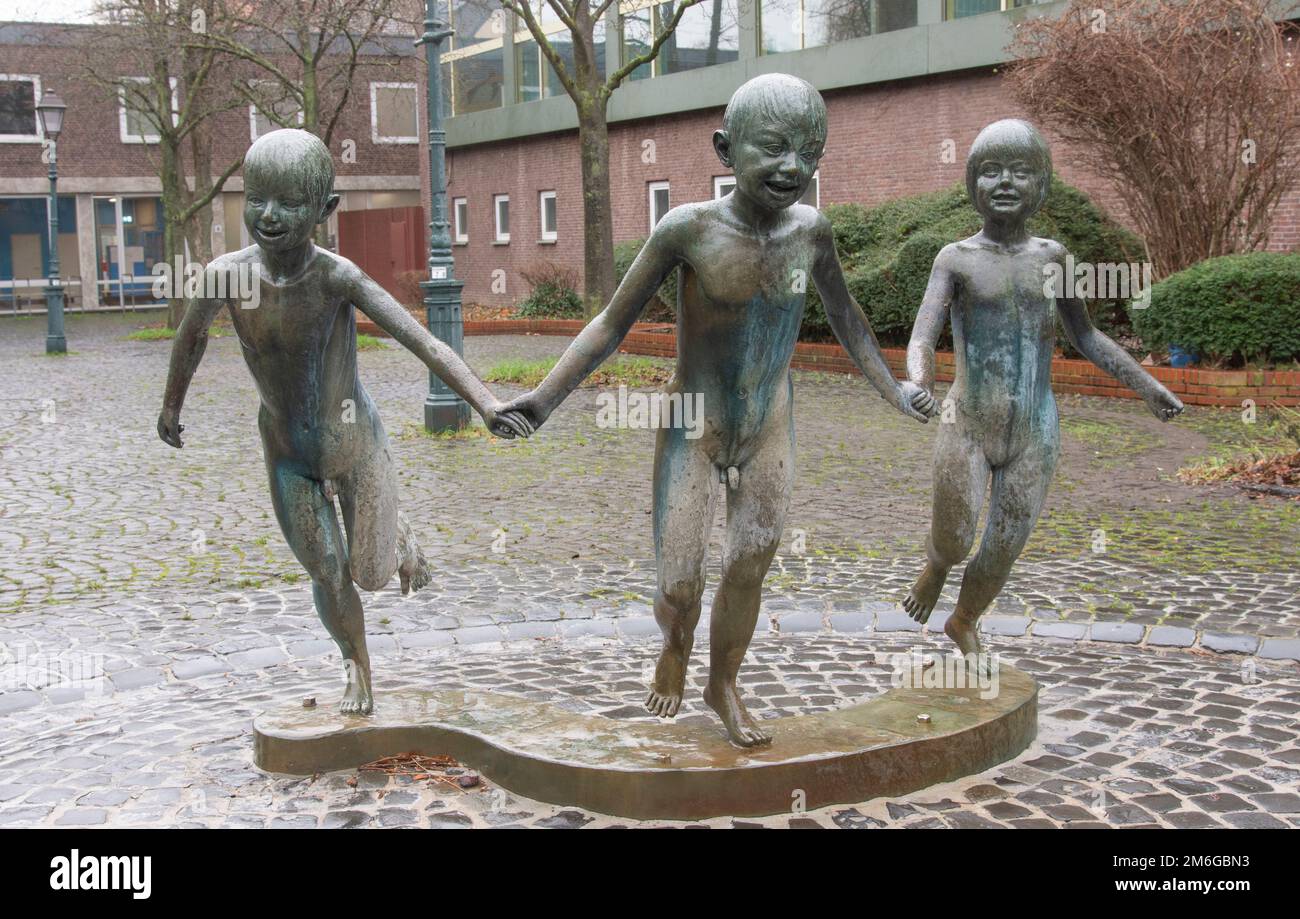 Aachen January 2023: Aachen, St.-Josefs-Platz, in front of the east swimming pool. Three children run into the cool water, bronze.Bonifatius Stirnberg Stock Photo