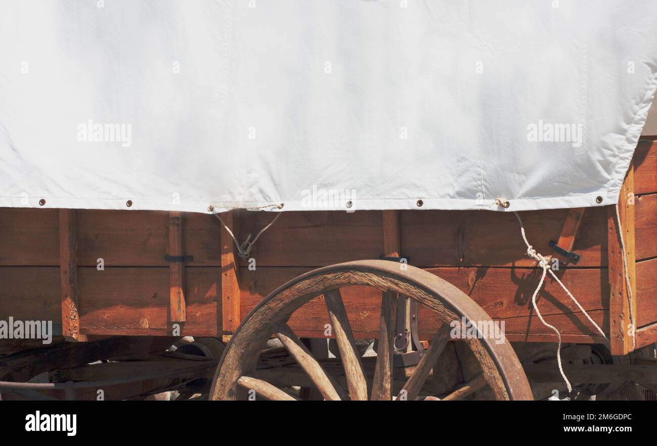 Covered wagon with clean white canvas side and wooden wheels can be