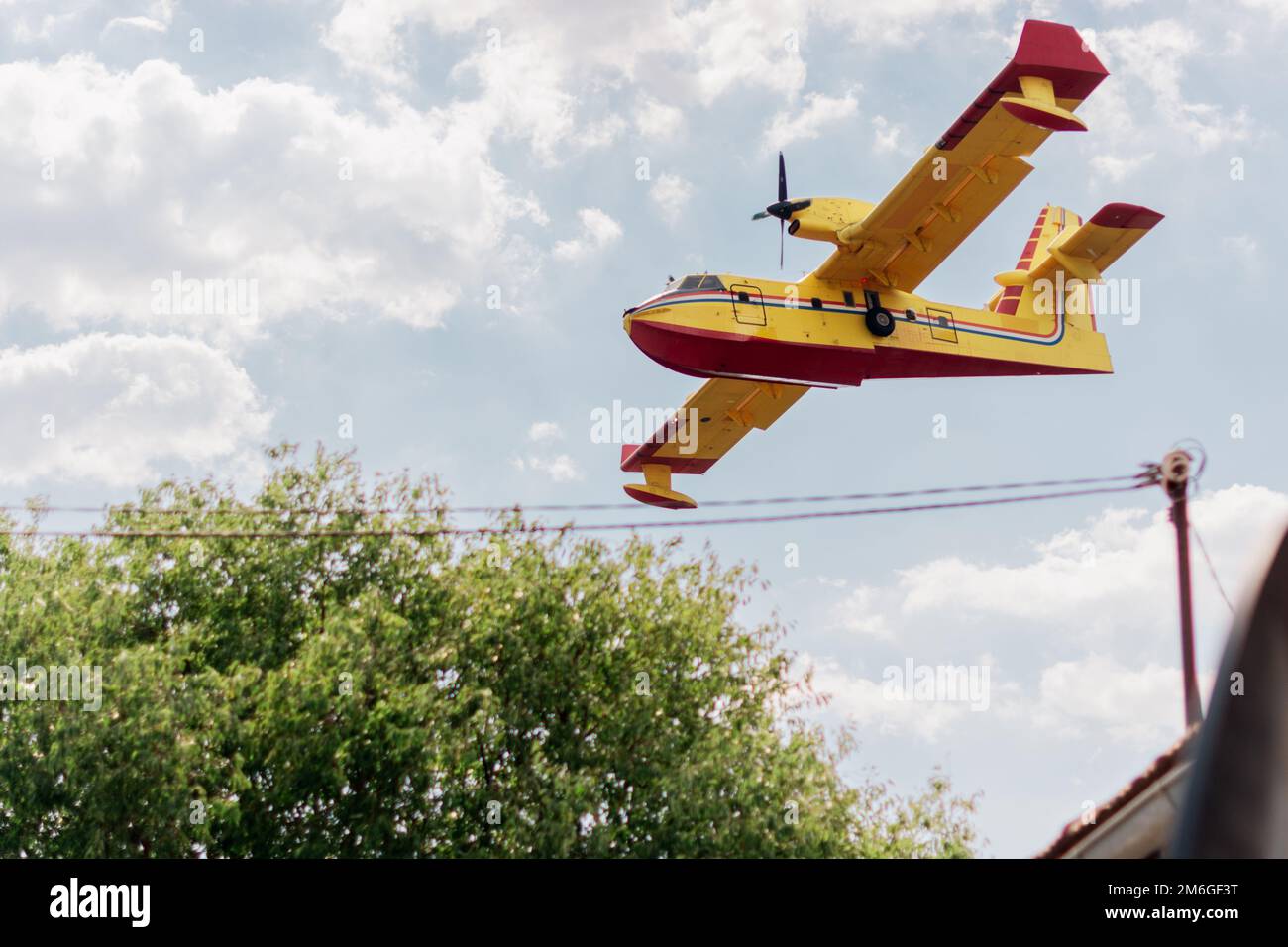 Firefighter airplane flying close to houses in the village Stock Photo