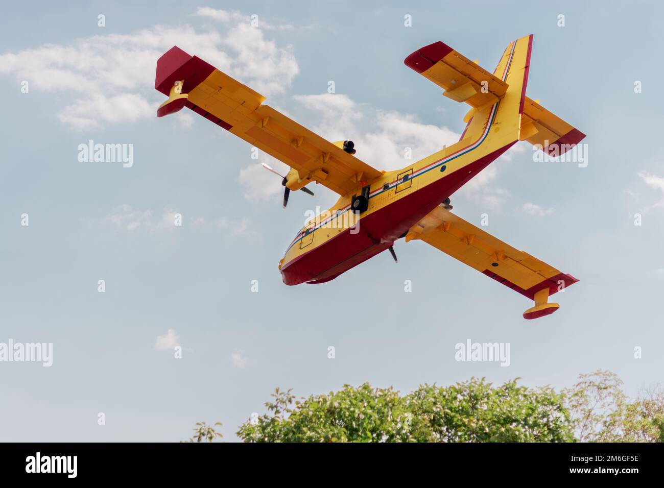 Firefighter airplane flying low in the village Stock Photo