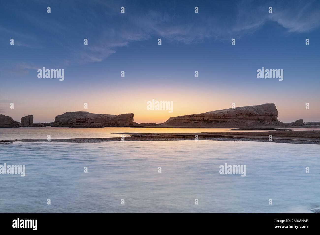 Yardang landform on water in sunset Stock Photo