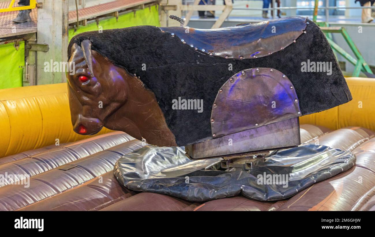 Large Rodeo Mechanical Bull Riding Machine at Amusement Park Stock Photo