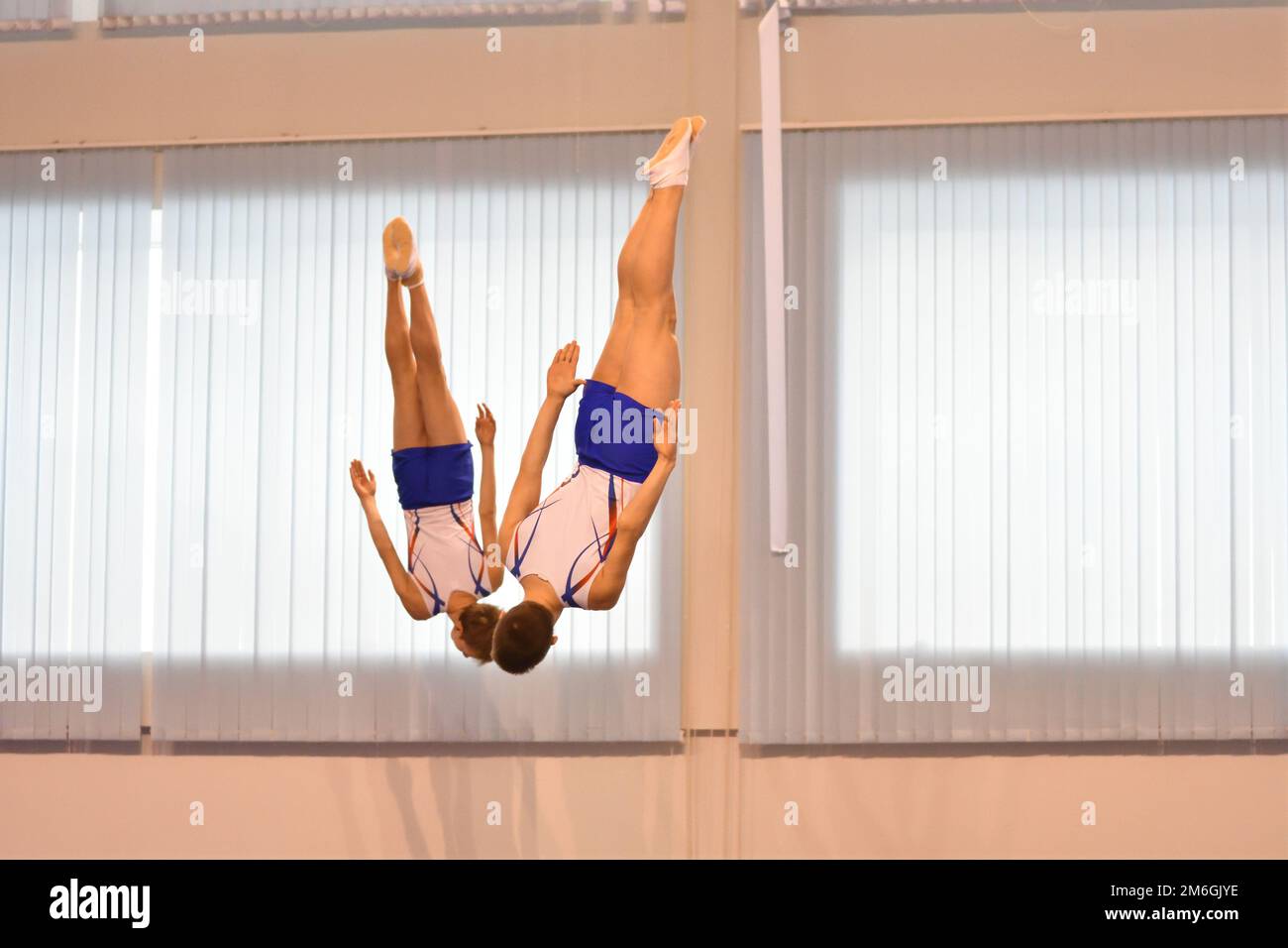 Two boys train in synchronized jumping on a trampoline Stock Photo Alamy