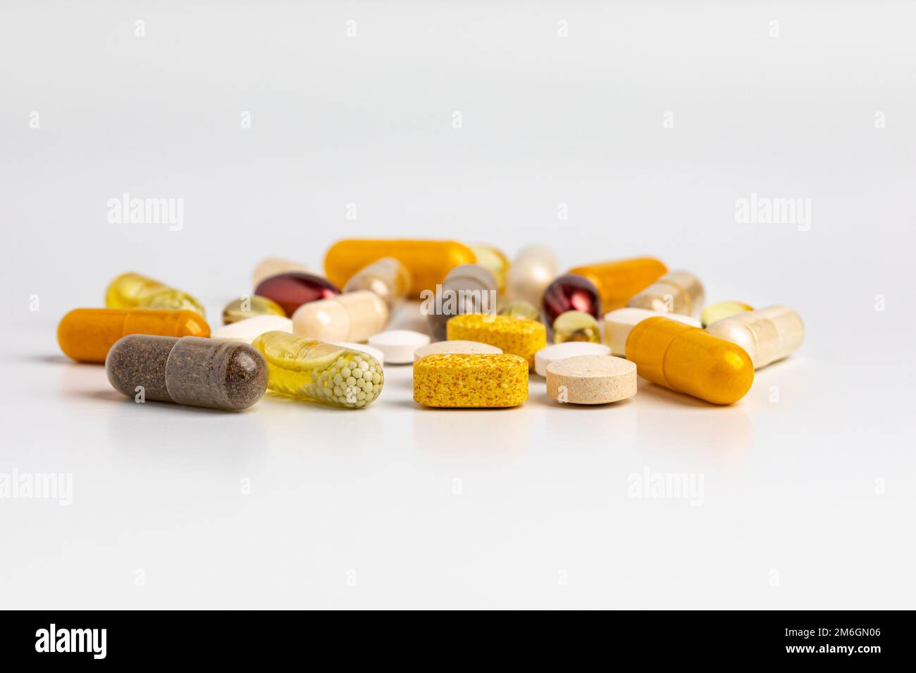 Variety of vitamins and nutritional supplements isolated on white background. Wellness, health care and nutrition concept. Stock Photo