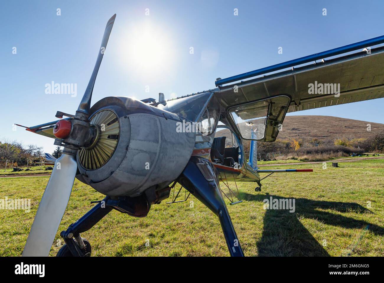 A small light-engine aircraft stands on a field airfield Stock Photo