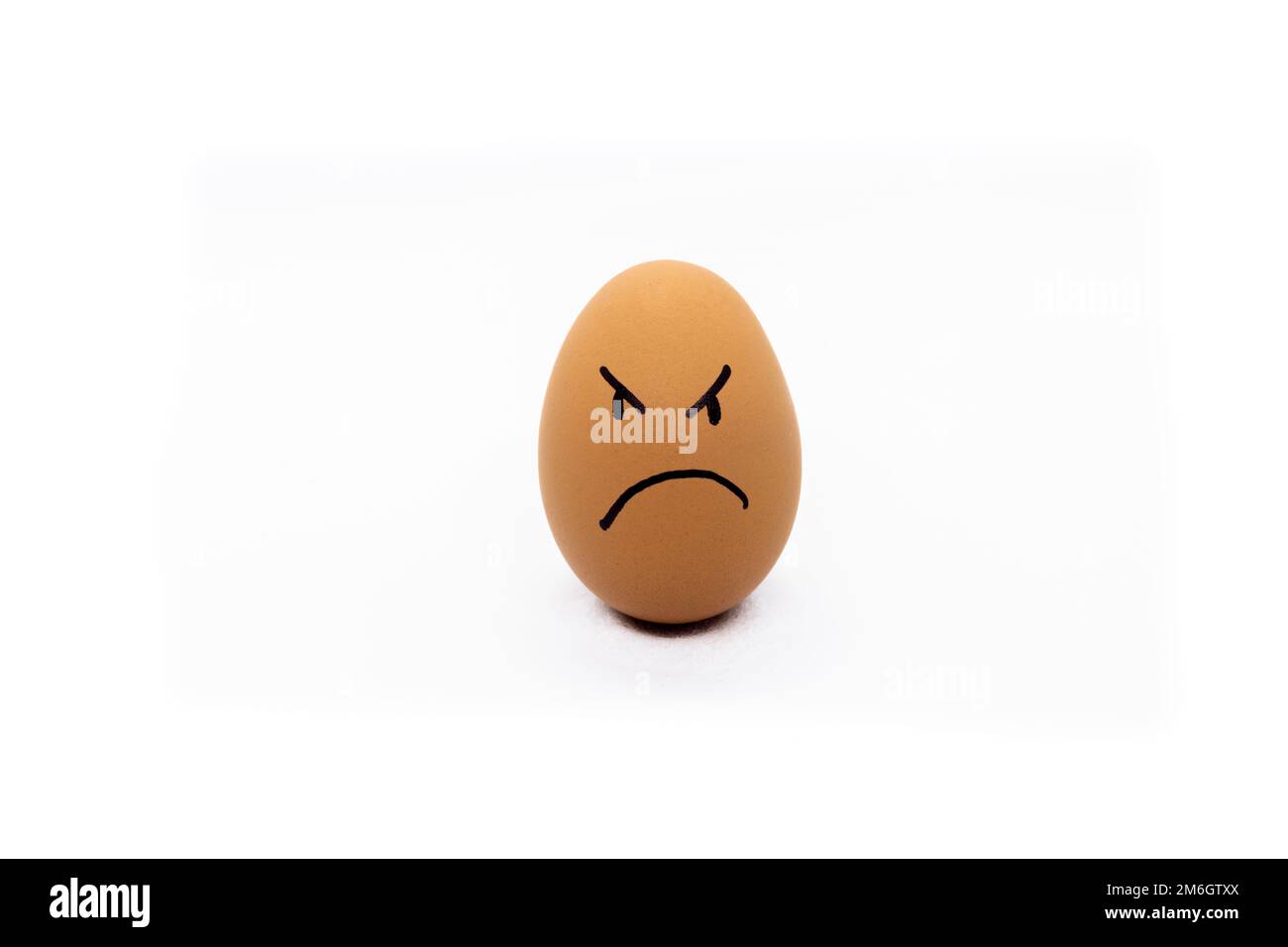 Egg with angry face on white background Stock Photo