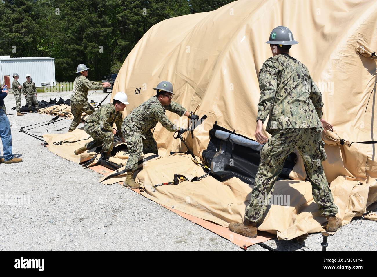 NMRLC Design Team Lt.j.g. Ryan Siwy leads a team as air beam tents are deflated to properly control how they are deflated for faster storage. NMRLC supports readiness by providing deployable medical systems, high-quality eyewear and ophthalmic devices, and fleet logistics solutions. The command's vision is to be Navy Medicine's premiere integrated medical logistics support activity. Stock Photo