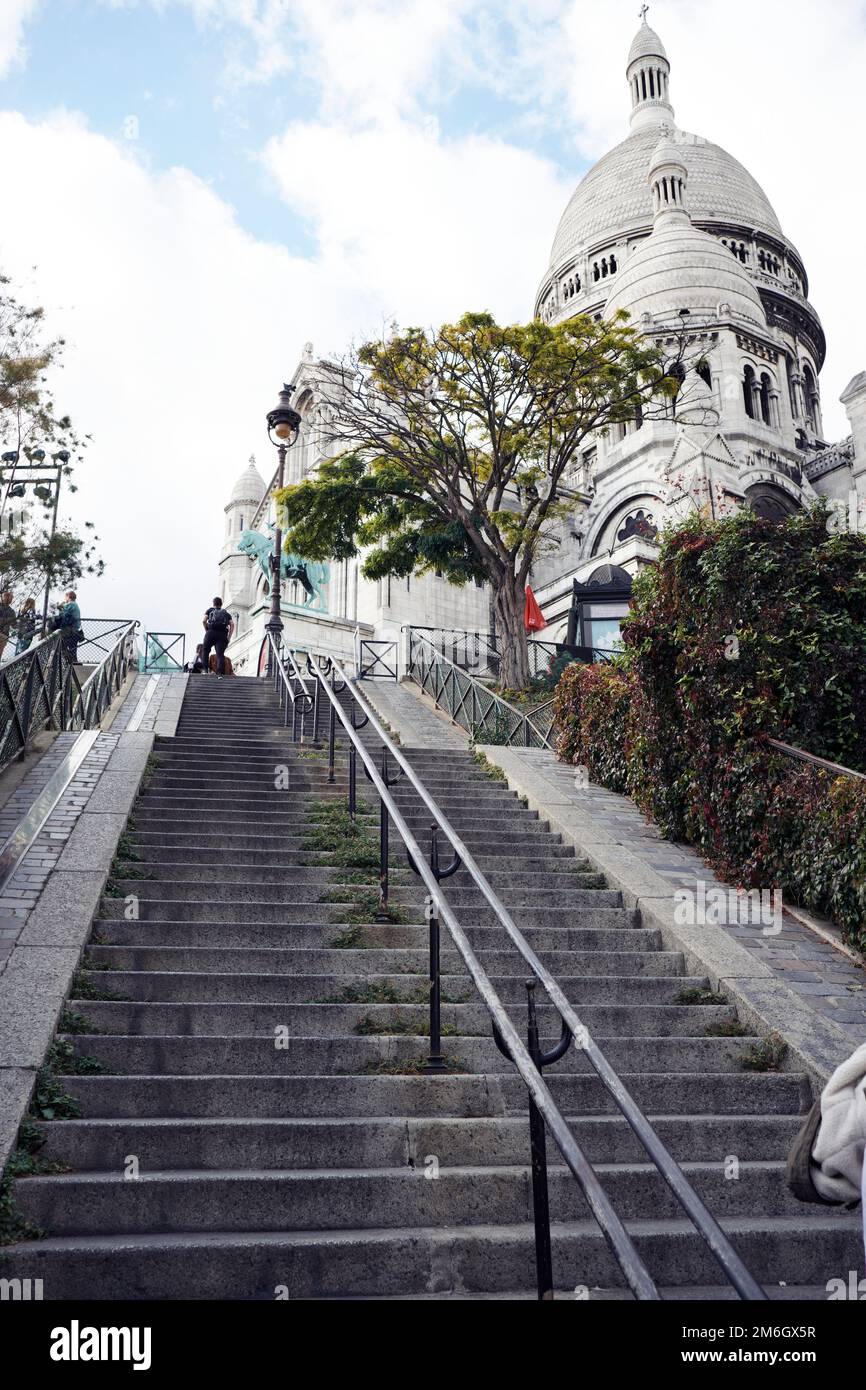 A view looking up steps towards The Basilica of the Sacred Heart of Paris Stock Photo