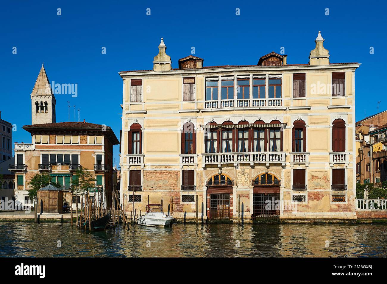 View of a typical Venetian facade with its façade damaged by the effect of water and a wooden pier for small boats Stock Photo