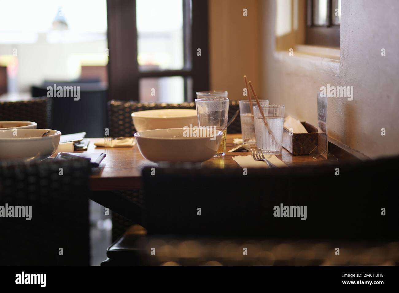 Restaurant tables with dirty dishes left in natural light Stock Photo