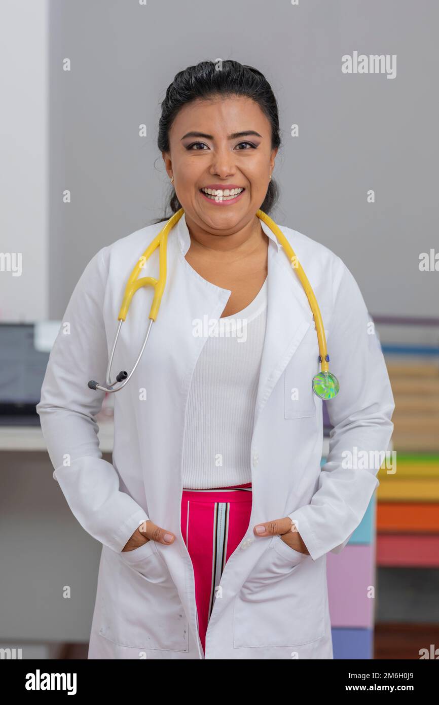 Portrait of a smiling pediatrician doctor in his office, wearing a lab coat and a stethoscope. Stock Photo