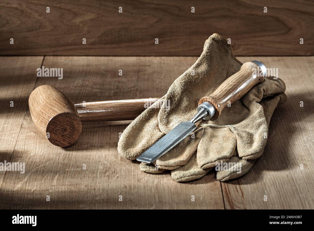 a round mallet chissel and gloves on wood background Stock Photo